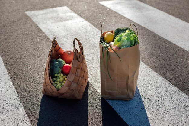 Photo des aliments sains dans des sacs à provisions écologiques se dressent sur un passage pour piétons
