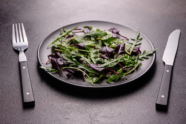 Aliments sains, mélange de salade avec roquette, épinards, sang de taureaux, feuilles de betterave et micro-légumes.