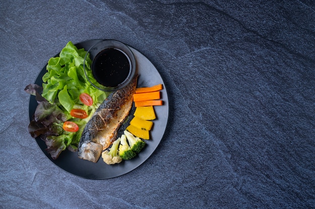 Aliments sains et propres composés de poisson saba grillé, d'herbes de légumes et de sauces japonaises