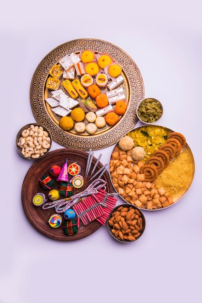 aliments sucrés indiens servis avec un assortiment de craquelins dans une assiette séparée montrant le concept de diwali