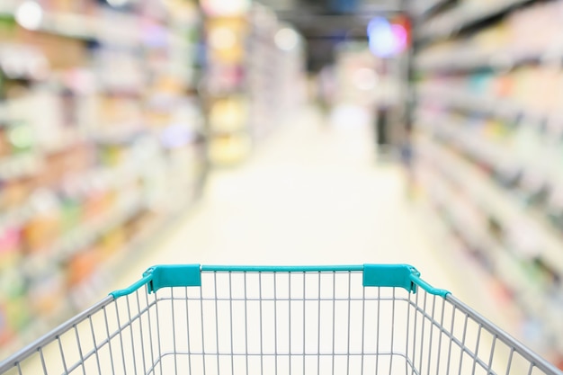 Allée de supermarché flou avec panier gblue vide