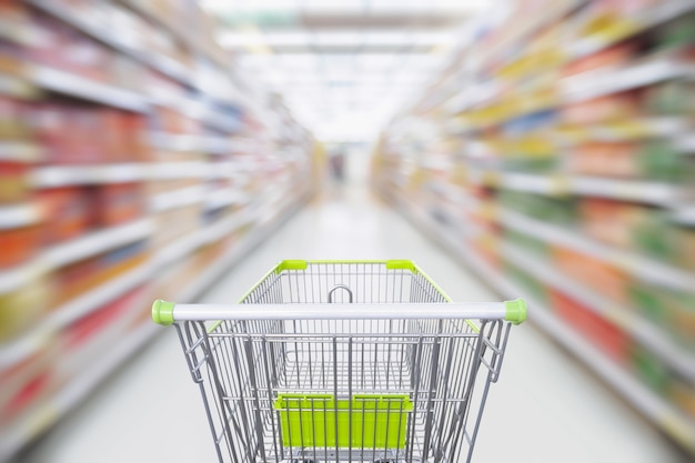 Allée de supermarché avec panier vert vide en mouvement