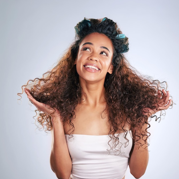 Aller pour quelques boucles aujourd'hui Photo recadrée d'une jolie jeune femme posant en studio sur un fond gris