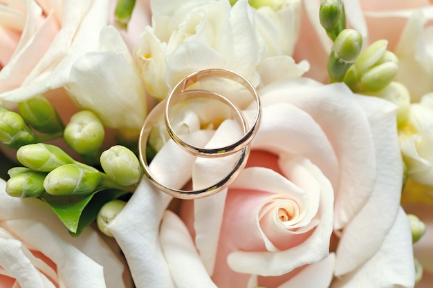 Alliances en or sur un bouquet de fleurs pour la mariée