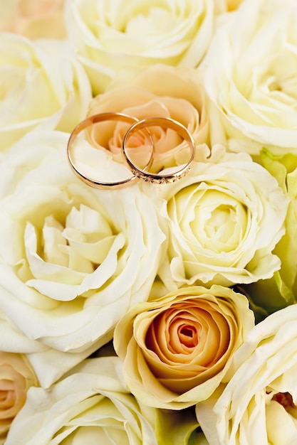 Alliances en or sur un bouquet de fleurs pour la mariée