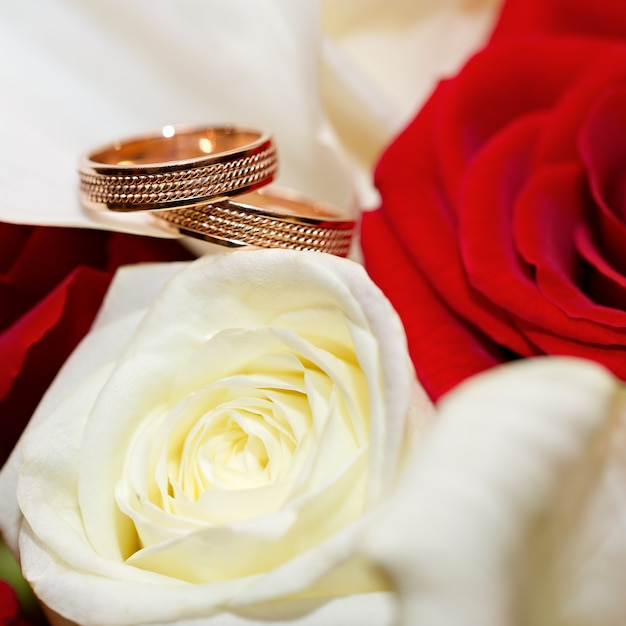 Alliances en or sur un bouquet de fleurs pour la mariée
