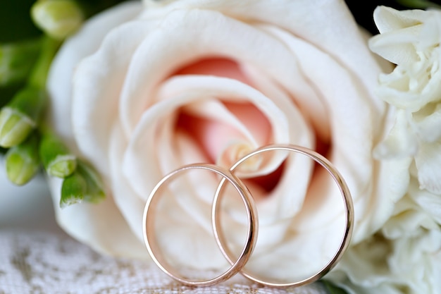 Alliances en or sur un bouquet de fleurs pour la mariée