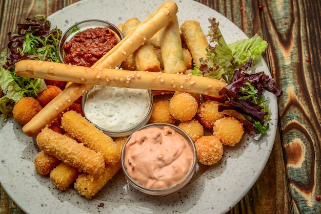 Allsorts de collations frites avec deux sauces différentes sur fond noir