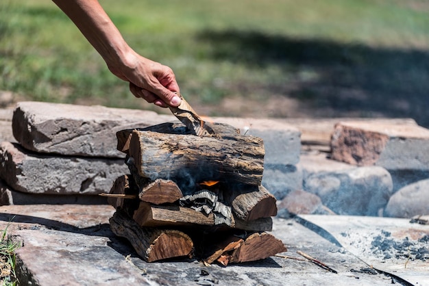 Allumage à la main des bûches de feu sur le feu cuisine argentine typique viande grillée viande grillée