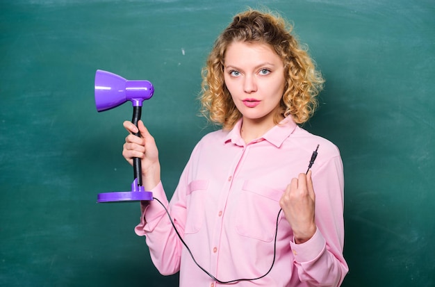 Allumer le processus d'étude L'enseignant tient la lampe de table à la main sur fond de tableau Perspicacité et idée Femme travaille sur une idée brillante et brillante Créativité et inspiration Idée éducative Journée de la connaissance