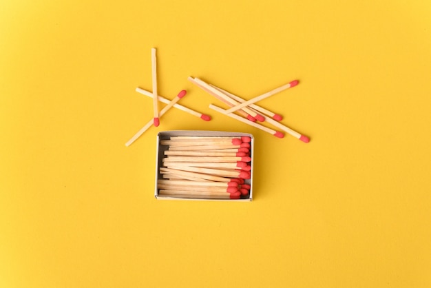 Allumettes rouges sur la table jaune.