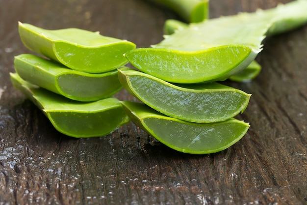 Aloe vera gel sur une cuillère en bois avec aloe vera sur table en bois