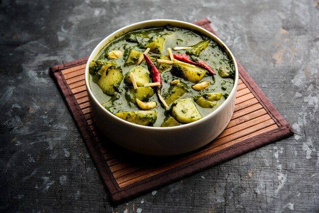 Aloo Palak sabzi ou curry de pommes de terre aux épinards servi dans un bol. Recette saine indienne populaire. Mise au point sélective