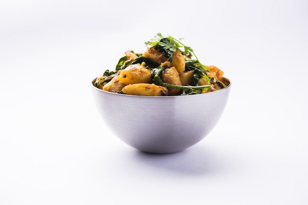 Aloo Palak sabzi - Pomme de terre cuite avec des épinards avec des épices ajoutées. une recette de plat principal indien sain. Servi dans un bol, mise au point sélective