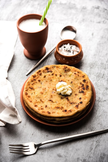 Aloo Paratha ou pain plat farci aux pommes de terre indiennes avec du beurre sur le dessus. Servi avec Lassi doux frais, chutney et cornichon. mise au point sélective