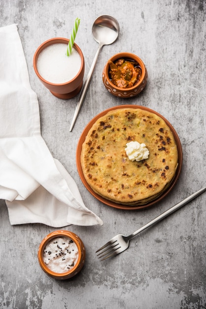 Aloo Paratha ou pain plat farci aux pommes de terre indiennes avec du beurre sur le dessus. Servi avec Lassi doux frais, chutney et cornichon. mise au point sélective