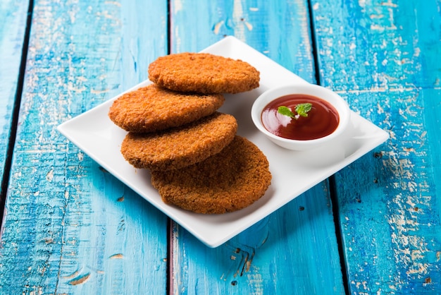 Aloo Tikki ou galettes ou escalopes est une collation ou une collation populaire d'Inde, servie avec du ketchup de tomate ou du chutney d'Imli sur fond de mauvaise humeur. Mise au point sélective