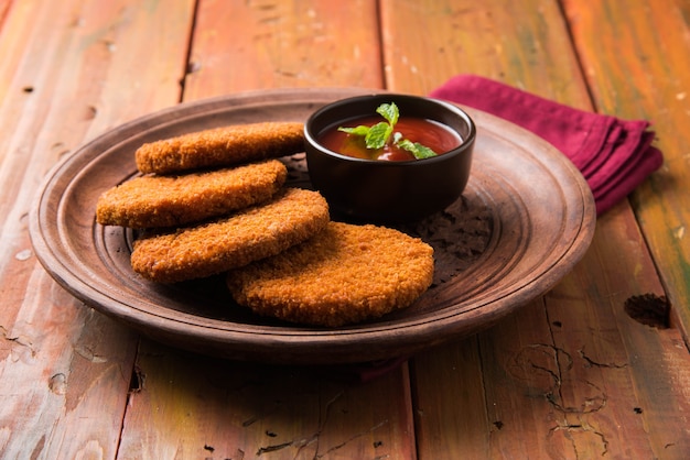 Aloo Tikki ou galettes ou escalopes est une collation ou une collation populaire d'Inde, servie avec du ketchup de tomate ou du chutney d'Imli sur fond de mauvaise humeur. Mise au point sélective