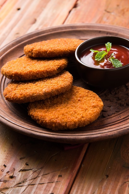 Aloo Tikki ou galettes ou escalopes est une collation ou une collation populaire d'Inde, servie avec du ketchup de tomate ou du chutney d'Imli sur fond de mauvaise humeur. Mise au point sélective