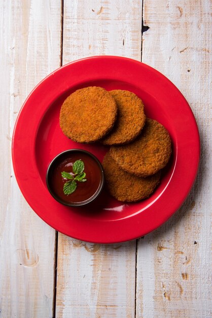 Aloo Tikki ou galettes ou escalopes est une collation ou une collation populaire d'Inde, servie avec du ketchup de tomate ou du chutney d'Imli sur fond de mauvaise humeur. Mise au point sélective