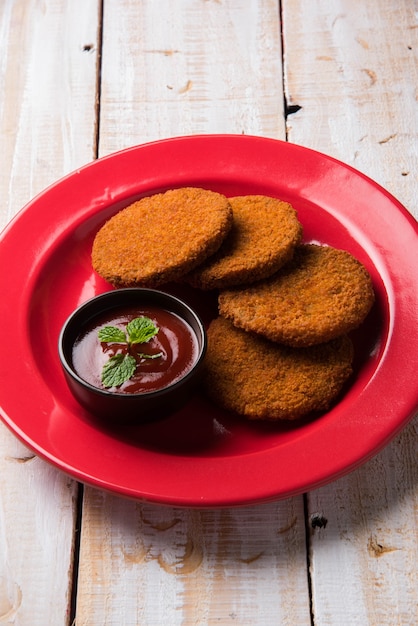 Aloo Tikki ou galettes ou escalopes est une collation ou une collation populaire d'Inde, servie avec du ketchup de tomate ou du chutney d'Imli sur fond de mauvaise humeur. Mise au point sélective