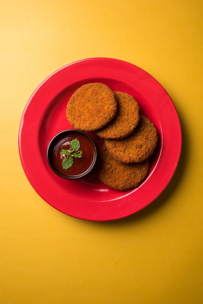 Aloo Tikki ou galettes ou escalopes est une collation ou une collation populaire d'Inde, servie avec du ketchup de tomate ou du chutney d'Imli sur fond de mauvaise humeur. Mise au point sélective