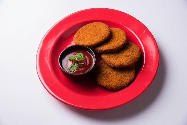 Aloo Tikki ou galettes ou escalopes est une collation ou une collation populaire d'Inde, servie avec du ketchup de tomate ou du chutney d'Imli sur fond de mauvaise humeur. Mise au point sélective