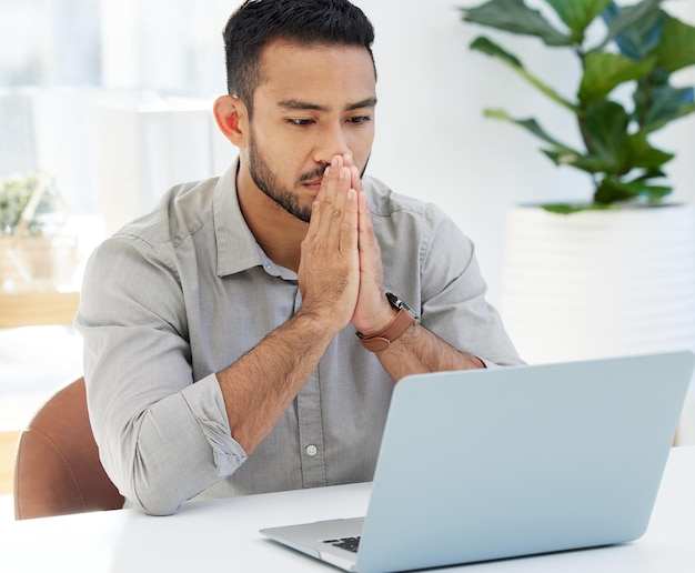 Alors, comment allons-nous résoudre ce problème Photo d'un jeune homme utilisant son ordinateur portable au travail dans un bureau moderne