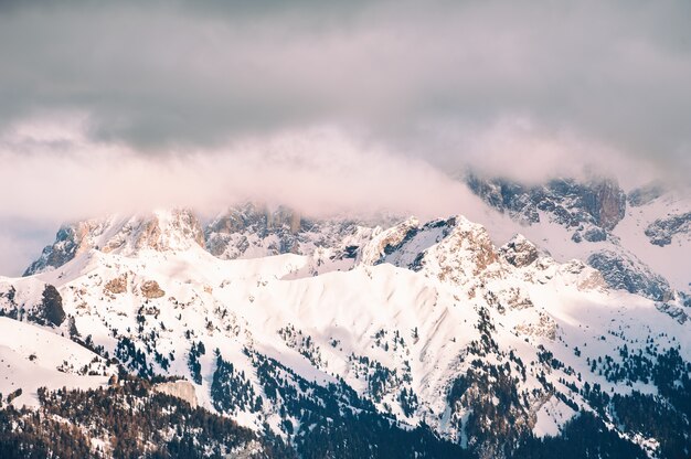 Photo alpes dolomitiques d'hiver couvertes de neige au coucher du soleil. val di fassa, italie