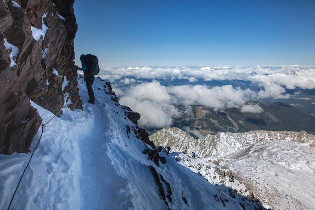 Alpinisme montant au dessus des nuages dans les Alpes françaises