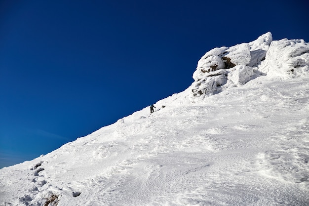 Alpiniste homme marchant sur la colline couverte de neige fraîche. Montagnes carpates