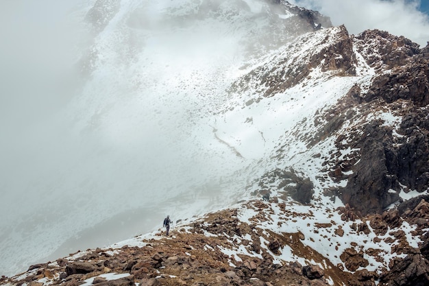 Alpiniste mâle marchant en montée sur la neige gelée dans le volcan izitaccihuatl