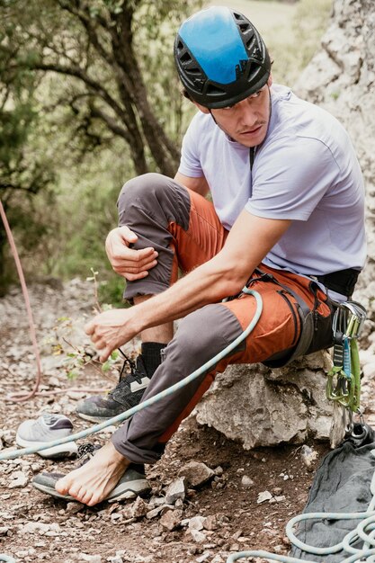 Photo un alpiniste professionnel enlève ses chaussures pour l'escalade