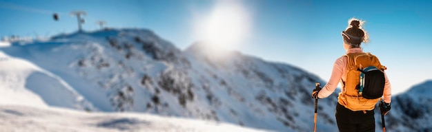 Alpiniste randonnée à ski dans l'arrière-pays ski alpiniste dans les montagnes Ski de randonnée dans un paysage alpin avec des arbres enneigés Sports d'hiver aventure