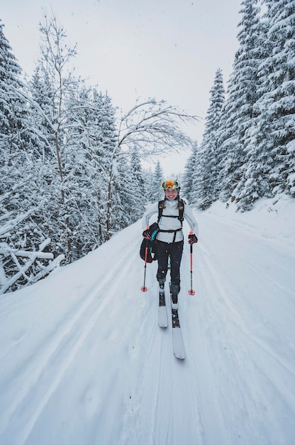 Photo alpiniste randonnée à ski dans l'arrière-pays ski alpiniste dans les montagnes ski de randonnée dans un paysage alpin avec des arbres enneigés sports d'hiver aventure