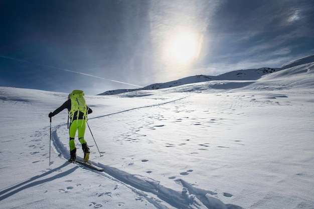 Alpiniste skieur seul sur piste balisée