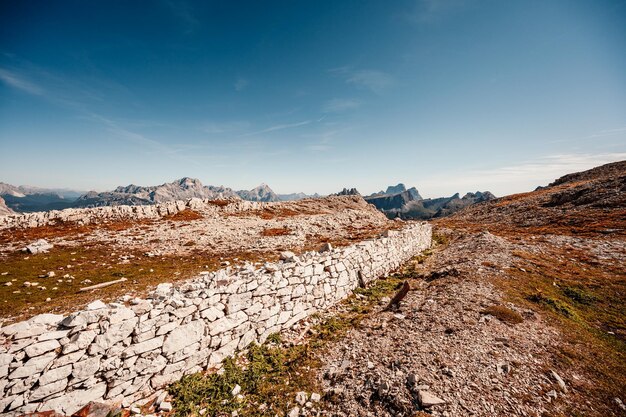 Alpiniste sur une Via Ferrata raide et exposée Col dei Bos près de passo falzarego Paysage majestueux de l'automne rouge alpin Passo Falzarego Tofana Italie près de Cortina d'Ampezzo