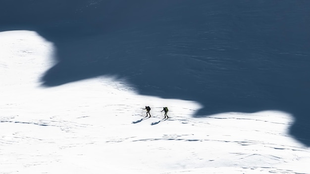 Alpinistes à ski à l'ombre des montagnes Photo de style artistique
