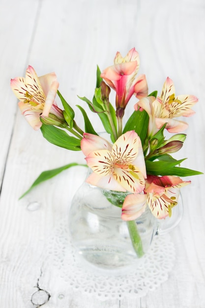 Alstroemeria de fleur dans un vase en verre sur un fond en bois
