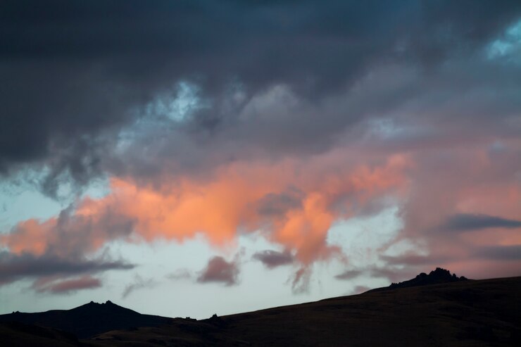 Altai Ukok le coucher du soleil sur les montagnes par temps froid nuageux. Endroits éloignés sauvages, personne autour. Nuages de pluie sur les montagnes