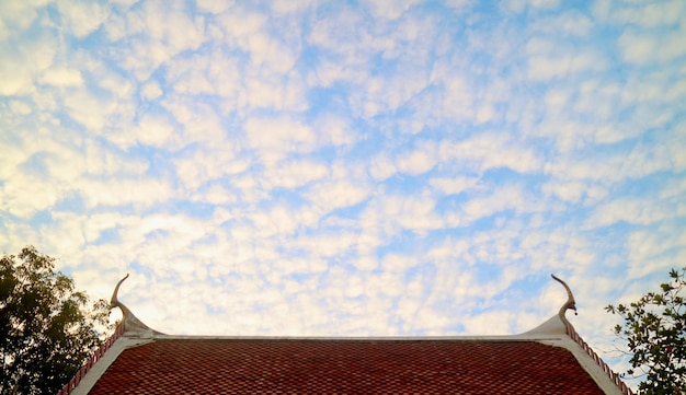Altocumulus étonnants alignés sur le ciel au-dessus du toit à pignon du temple bouddhiste