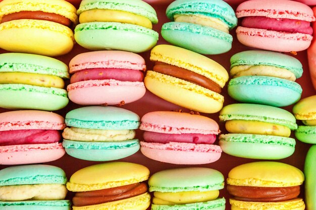 Amande douce colorée rose, bleu, jaune, vert macaron ou fond de gâteau dessert macaron. Biscuit sucré français. Concept de boulangerie alimentaire minimal. Mise à plat, vue de dessus, espace de copie