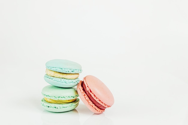 Amande douce rose pastel coloré bleu vert macaron ou gâteau dessert macaron isolé sur blanc