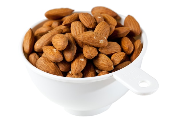 Amandes biologiques crues dans une tasse à mesurer