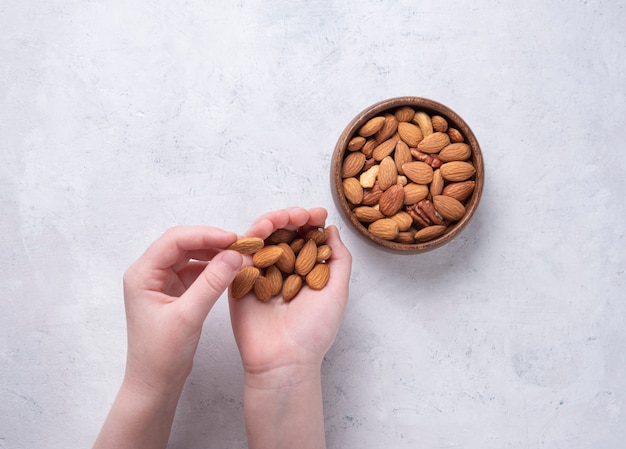 Amandes sur bol en bois sur fond gris