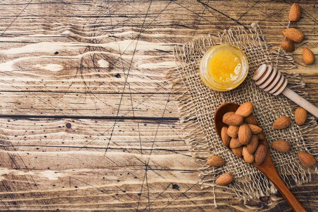 Amandes en cuillère en bois sur fond en bois.