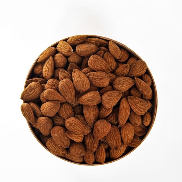 amandes dans une boîte en bois sur fond blanc