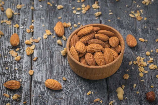 Amandes dans un bol blanc sur un morceau de toile de jute sur une table en bois Nourriture végétarienne Mise à plat