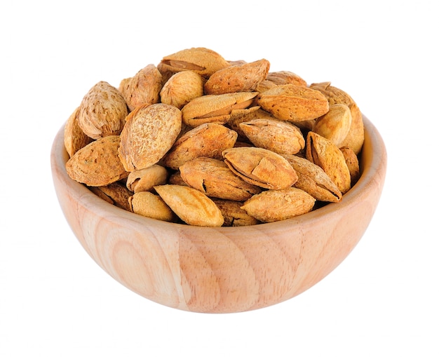 Amandes dans un bol en bois isolé sur fond blanc