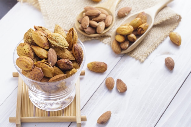 Amandes dans un bol noir sur fond de bois rustique foncé